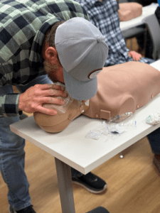 Performing CPR giving breaths on a Prestan manikin