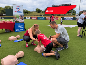 Child practicing Hands-Only CPR with CPR Choice at the 2026 Greater Knoxville Heart Walk at Covenant Health Park.